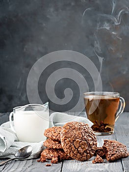 Brownie cookies on a wooden table with tea and milk. Copy space