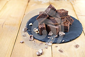 Brownie cubes and crumbled chocolate on a black stone tile