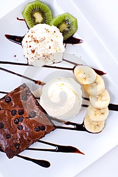 Brownie and ice cream with whipping cream and banana slices