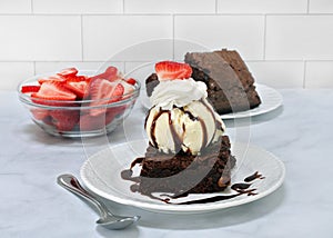 Brownie sundae with whipped cream, vanilla ice cream & strawberries