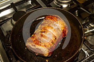 Browning a beef brisket joint , in a frying pan