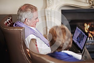 Browsing through their holiday pictures. A senior couple looking at photos taken during the day while on a vacation.