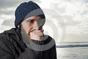 Brrr, its a cold morning...a cold-looking young man trying to keep warm at the ocean. photo