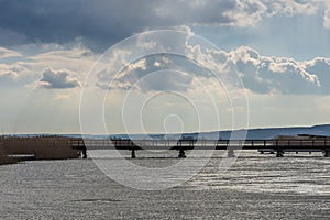 bruecke am see mit wolken am himmel