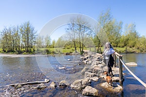 Brug Molenplas, stepping stones, mature tourist with her dachshund standing, smiling and looking camera