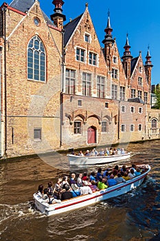 BRUGES, BELGIUM - APRIL 6, 2008: Tourists float on a boat through the Dijver channel