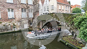 Tourist sightseeing boat on canal in Bruges in winter, Bruges, Belgium