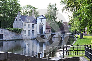 BRUGES, BELGIUM - JUNE 14, 2019: Bridge over canal and entrance gate to the Princely Beguinage Ten Wijngaerde