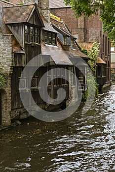 Bruges, Belgium. Medieval ancient houses made of old bricks at water channel in old town. Picturesque landscape.