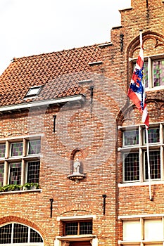 Bruges city symbol, the Brugs Beertje on the facade of the Poortersloge