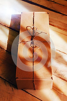 The brun squared present box with jute rope on a wooden background photo