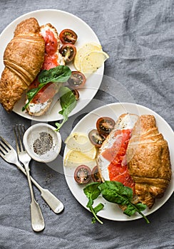 Brunch or breakfast table - croissants with cream cheese and smoked salmon, and cherry tomatoes. Delicious balanced breakfast, br