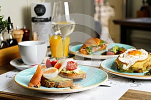 Brunch table with Avocado toast with guacamole, soft boiled egg, salmon, cream cheese and tomatoes on a plate