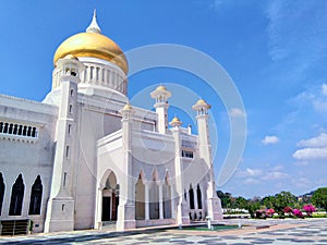 Brunei Darussalam, Bandar Seri Begawan - March 17, 2019: The Omar Ali Saifuddien Mosque with golden dome. Entrance gate with flowe