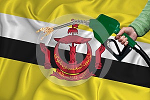 BRUNEI flag Close-up shot on waving background texture with Fuel pump nozzle in hand. The concept of design solutions. 3d