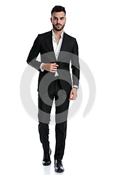 Businessman walking with one hand loose and one on jacket