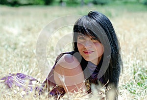 Brunet woman lying in grass