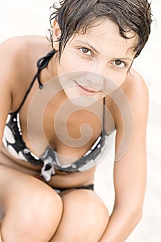 Brunet woman sitting on a sand