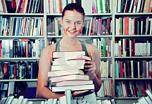 Brunete girl chooses a book in university library