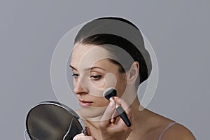 Brunette applying foundation with a brush