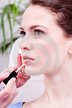 Woman applying lipstick on lips natural beauty