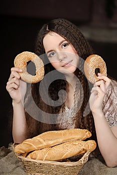 Brunette with a basket with rolls and bagels