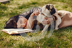 Brunette in a brown coat walks with pug