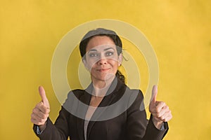 Brunette business woman over  background making happy thumbs up