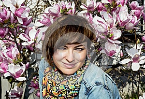 Brunette caucasian woman and blooming magnolia