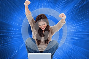 Brunette cheering while using laptop