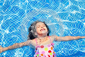 Brunette children girl swimming blue tiles pool