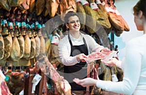 Brunette choosing iberico and serrano jamon and smiling