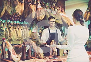 Brunette choosing iberico and serrano jamon and smiling