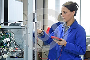 Brunette electrician holding calibrating device