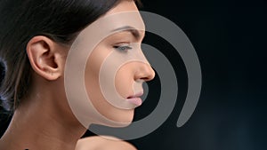 Brunette fashion female model stroking tender softness neck face skin plastic surgery isolated black