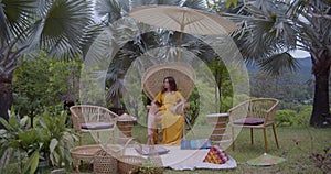 Brunette female having picnic time on the tropical glade