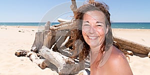 Brunette forties woman in low top on the beach on a sunny day happy smile in web banner template header vacation