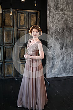 A brunette girl in a beautiful dress posing for a photographer