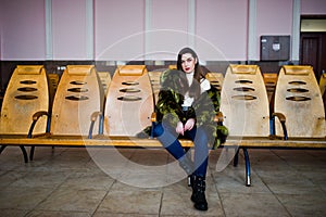 Brunette girl in green fur coat at winter day