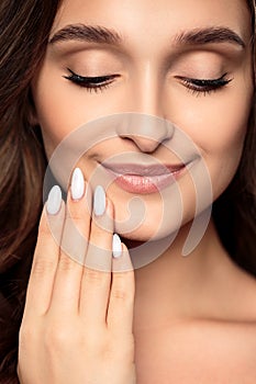 Brunette girl with healthy curly hair and natural make up . Beautiful model woman with wavy hairstyle