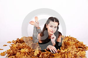 Brunette girl lying on autumn leaves