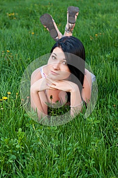 Brunette girl lying on grass.