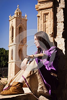 Brunette girl in a medieval suit in a Agia Napa Medieval Monaste