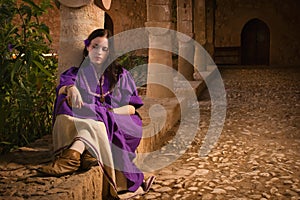 Brunette girl in a medieval suit in a Agia Napa Medieval Monastery