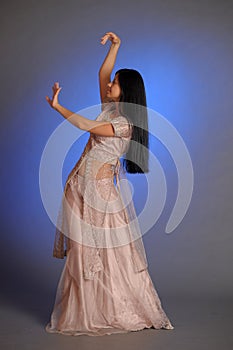 Brunette girl in oriental dress on a blue background in the studio