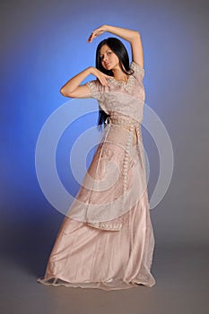 Brunette girl in oriental dress on a blue background in the studio