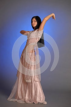 Brunette girl in oriental dress on a blue background in the studio