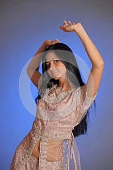 Brunette girl in oriental dress on a blue background in the studio