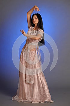 Brunette girl in oriental dress on a blue background in the studio