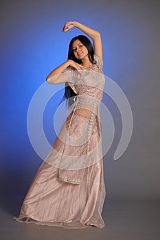 Brunette girl in oriental dress on a blue background in the studio